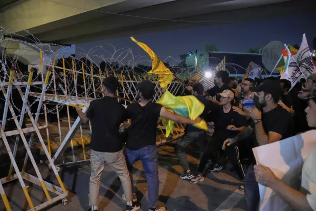 أنصار «الإطار التنسيقي» يحاولون إزالة حواجز وضعها الأمن العراقي لإغلاق الجسر المؤدي إلى المنطقة الخضراء حيث تقع السفارة الأميركية (أ.ب)