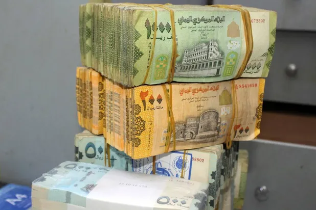 حزم من الأوراق النقدية اليمنية الجديدة والقديمة في أحد البنوك بعدن (غيتي)
