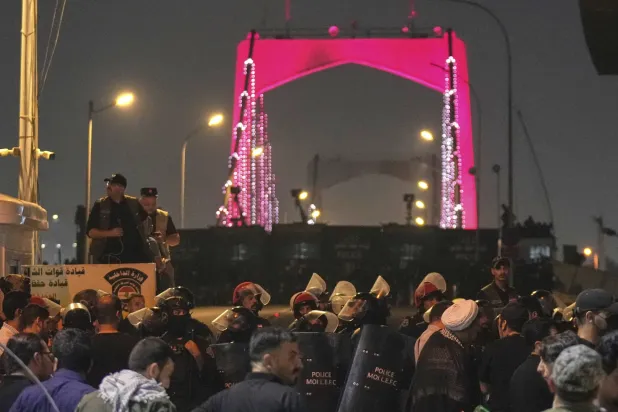 قوات أمن عراقية تقطع الطريق إلى الجسر المؤدي إلى السفارة الأميركية في المنطقة الخضراء ببغداد (أ.ب)