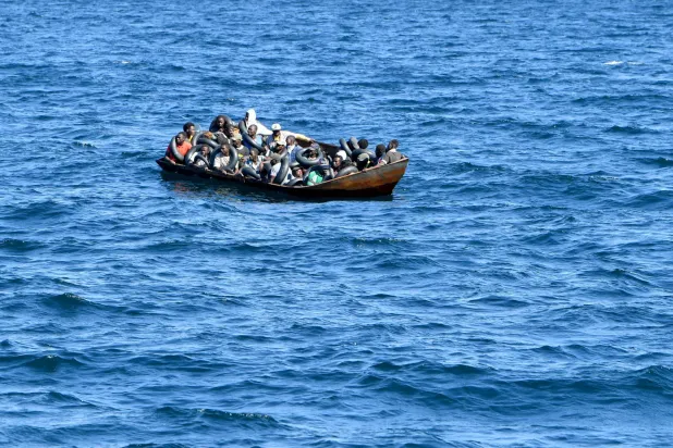 File photo: Migrants of African origin trying to flee to Europe are crammed on board of a small boat, as Tunisian coast guards prepare to transfer them onto their vessel, at sea between Tunisia and Italy, on August 10, 2023. (Photo by FETHI BELAID / AFP)