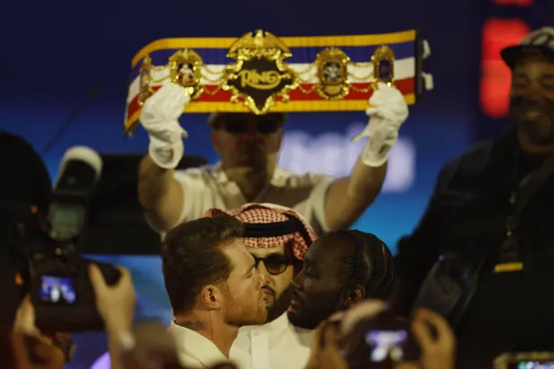 الملاكمان في لقطة تحدٍ أمام الكاميرات وسط متابعة آل الشيخ (رويترز)