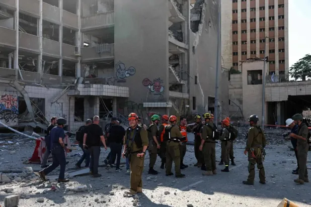Emergency personnel at an impact site following Iran's missile strike on Israel in Haifa, June 20, 2025. AFP 