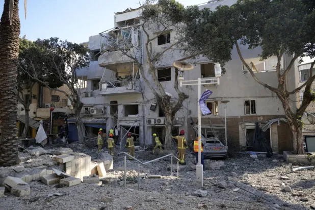 İtfaiyeciler İran'dan atılan bir roketin Hayfa'ya düştüğü yeri inceliyor (AP)