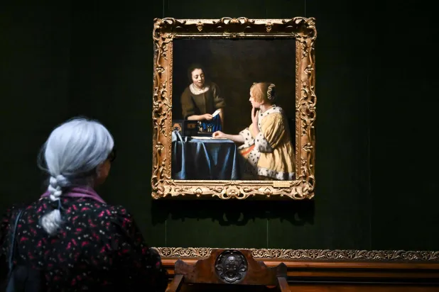 سيدة تنظر للوحة «العشيقة والخادمة» في مدينة نيويورك (أ.ف.ب)