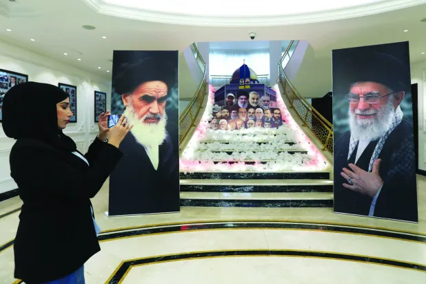 صورتا خامنئي والخميني تتقدمان صور قادة لبنانيين وفلسطينيين وإيرانيين قُتلوا بالمعارك مع إسرائيل بمبنى السفارة الإيرانية في بيروت (إ.ب.أ)