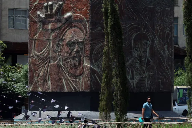 رجل يمر أمام تمثال للخميني في طهران (إ.ب.أ)