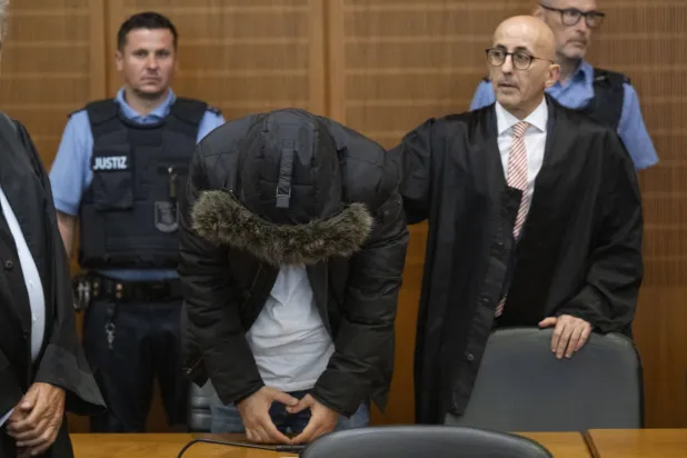 الطبيب السوري وإلى جانبه محامي الدفاع عنه في قاعة المحكمة في مدينة فرنكفورت (د.ب.أ)