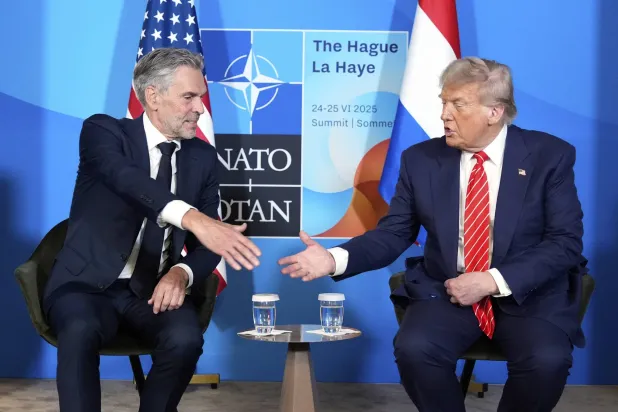 الرئيس الأميركي دونالد ترمب يصافح رئيس الوزراء الهولندي ديك شوف الأربعاء  في اجتماع على هامش قمة الناتو (أ.ب)