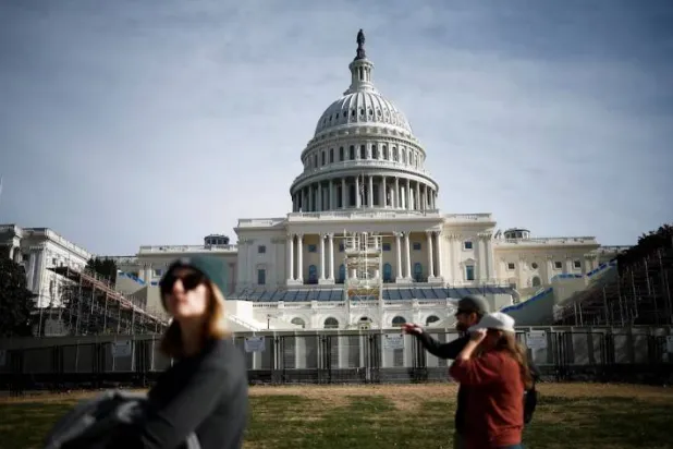 أشخاص يسيرون بجانب مبنى الكابيتول في واشنطن (رويترز)