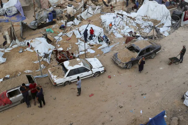 فلسطينيون يتجمعون في موقع غارة إسرائيلية على مدينة غزة (رويترز)