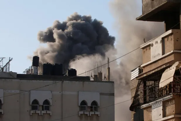 الدخان يتصاعد عقب غارة جوية إسرائيلية على منزل بمدينة غزة (رويترز)