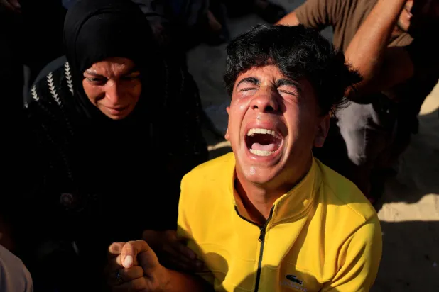 فلسطینی‌ای در حال فریاد هنگام تشییع اعضای خانواده‌اش که در حمله هوایی اسرائیل در خان‌یونس کشته شدند، در روز یکشنبه (رویترز)