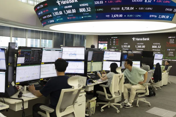 متداولون كوريون يتابعون مؤشر «كوسبي» في بنك «هانا» بسيول (إ.ب.أ)