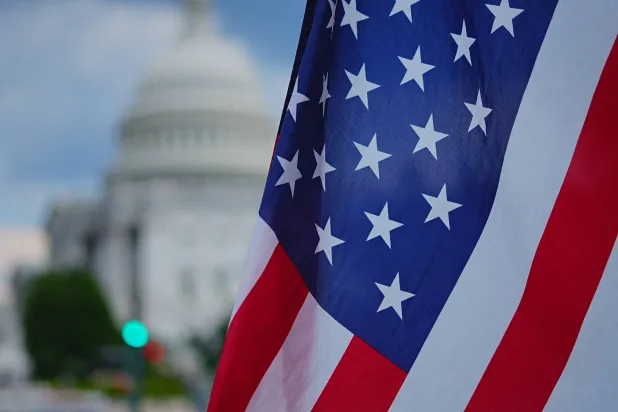 العلم الأميركي أمام الكابيتول بينما يناقش مجلس الشيوخ مشروع قانون ترمب الشامل للإنفاق والضرائب (رويترز)