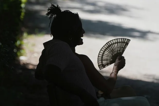 رجل يستريح في حديقة ريتيرو بمدريد (أ.ب)