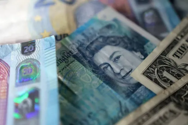 صورة توضيحية لأوراق نقدية من الجنيه الإسترليني والدولار الأميركي (رويترز)