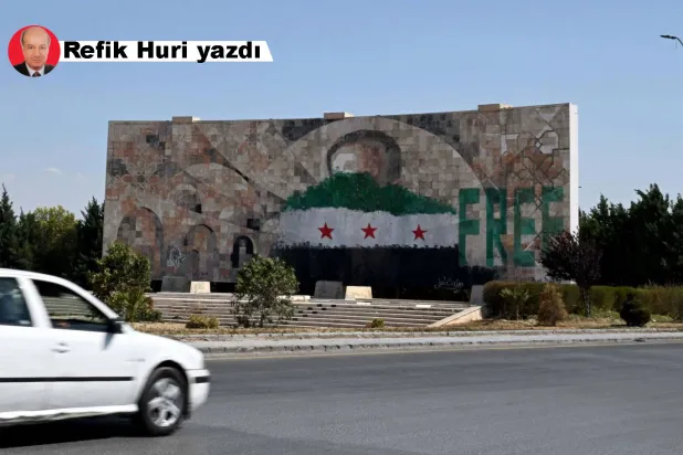 Eski Suriye devlet başkanı Hafız Esed'in yüzü “özgürlük” kelimesi ve yeni Suriye bayrağı ile kapatılmış (AFP)