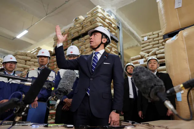 وزير الزراعة الياباني شينجيرو كويزومي يتفقد مخزونات الحكومة من الأرز في مدينة كاناغاوا (رويترز) 