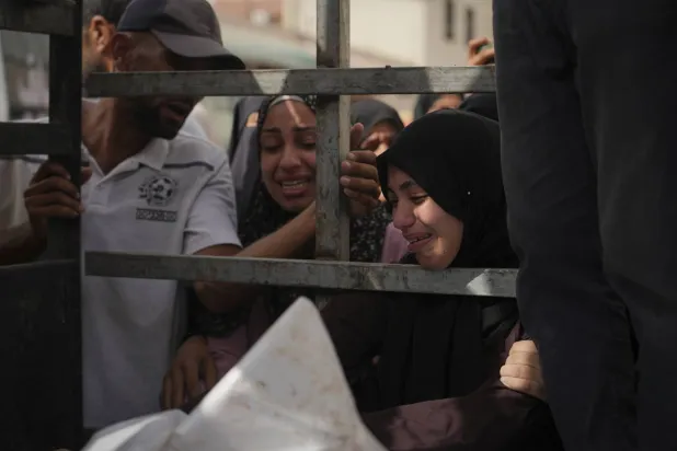 مشيعون يشاركون في تشييع جثمان أفراد عائلة العيماوي الذين استُشهدوا جراء قصف إسرائيلي على الزوايدة بمشرحة مستشفى الأقصى في دير البلح (أ.ب)