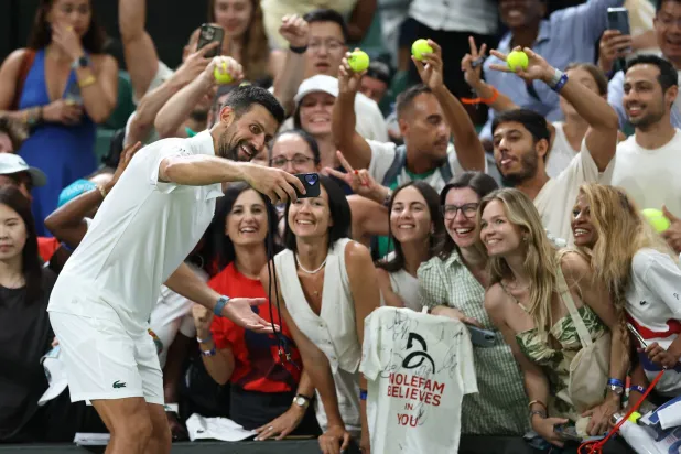 نوفاك يلتقط سيلفي مع معجباته في ويمبلدون (رويترز)