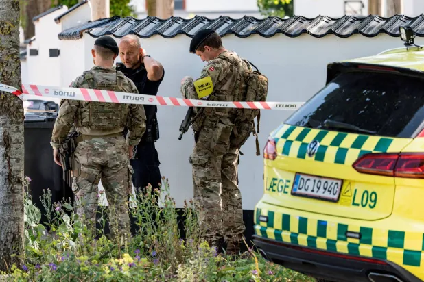 الشرطة الدنماركية تقف بمحطة نورجيسمينديفي في هيليروب بكوبنهاغن (رويترز)
