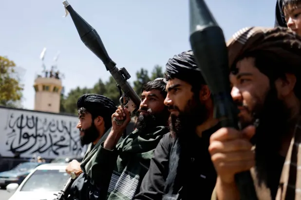 Taliban askerleri Kabil'in düşüşünün ikinci yıldönümünü Afganistan'daki ABD büyükelçiliğine yakın bir caddede kutluyor 15 Ağustos 2023 (Reuters)