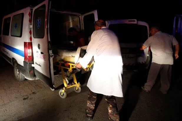 صورة أرشيفية لنقل أحد المصابين في سيارة إسعاف في تونس (رويترز)