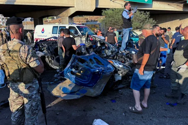 عناصر في الجيش اللبناني يعاينون موقع إستهداف سيارة في قصف إسرائيلي في منطقة خلدة جنوب بيروت قبل أيام (رويترز)