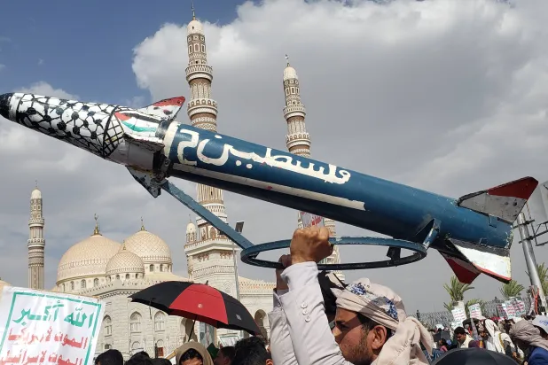 مناصرون للحوثي يحملون صاروخاً وهمياً خلال مظاهرة مناهضة لإسرائيل والولايات المتحدة بصنعاء 27 يونيو (إ.ب.أ)