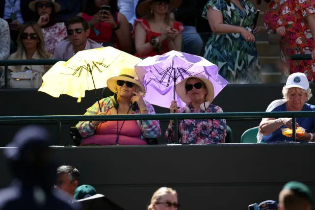 سيدتان تحتميان من الشمس في بطولة ويمبلدون ببريطانيا (إ.ب.أ)