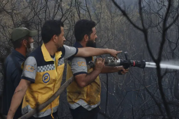 أعمال السيطرة على الحريق في قرية البركة ووادي كورنكول بمنطقة جبل التركمان في ريف اللاذقية (الدفاع المدني)