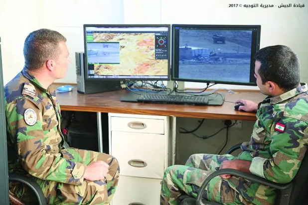 
عنصران في الجيش اللبناني يراقبان صوراً تبثها كاميرات المراقبة المثبتة على أبراج على الحدود مع سوريا (مديرية التوجيه)