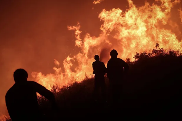 ليلة قاسية قضاها رجال الإطفاء أمس في مواجهة ألسنة اللهب وهبات الرياح والتضاريس الجبلية لمنع توسع النيران في جبل النسر بريف اللاذقية (الدفاع المدني)