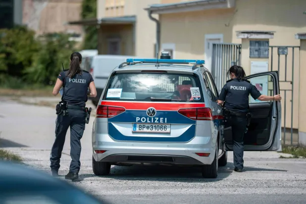 يقوم رجال الشرطة بتأمين المنطقة القريبة من مسرح الجريمة التي أطلق فيها مسلّح النار على رجل وأصاب امرأة بجروح خطيرة في تراسكيرشين بجنوب فيينا 13 يوليو 2025 (أ.ف.ب)