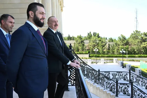 Azerbaycan Cumhurbaşkanı İlham Aliyev ve Suriye Cumhurbaşkanı Ahmed Şara, cumartesi günü Bakü'deki Cumhurbaşkanlığı Sarayı’nın terasından etrafı izlerken (AP)