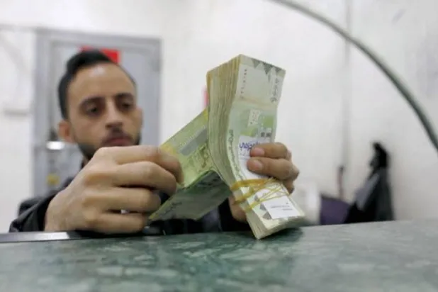 عامل يعد نقوداً في محل للصرافة بصنعاء (إ.ب.أ) 