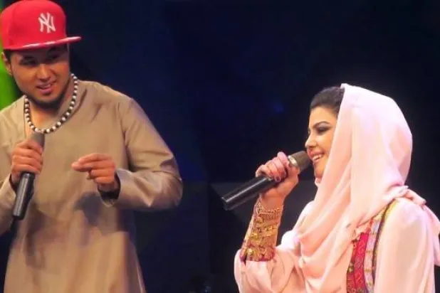 المغنية الأفغانية زلالة هاشمي (يمين) تؤدي أغنية إلى جانب منافسها سيد جمال مبارز (يسار) خلال مسابقة الموسيقى التلفزيونية «النجم الأفغاني» (أ.ف.ب)