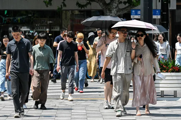 مشاة في أحد شوارع مدينة شنغهاي الصينية (أ.ف.ب)