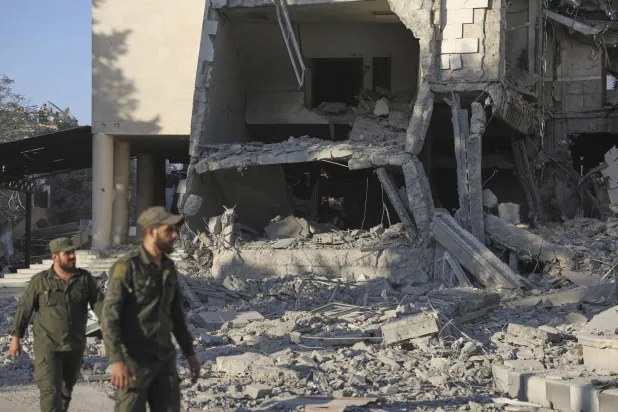 عنصر من قوات الأمن السورية يتفقد الأضرار التي لحقت بمبنى وزارة الدفاع عقب غارات إسرائيلية (أ.ب) 