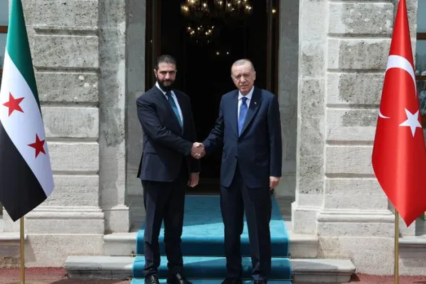 الرئيس التركي رجب طيب إردوغان مستقبِلاً الرئيس السوري الانتقالي أحمد الشرع بالمكتب الرئاسي بقصر دولمة بهشة في إسطنبول أمس (د.ب.أ)