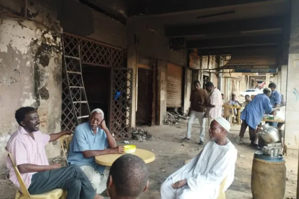 Esnaf Hartum'daki bir alışveriş merkezinde yanan dükkanlarının önünde toplanmış (Özel)