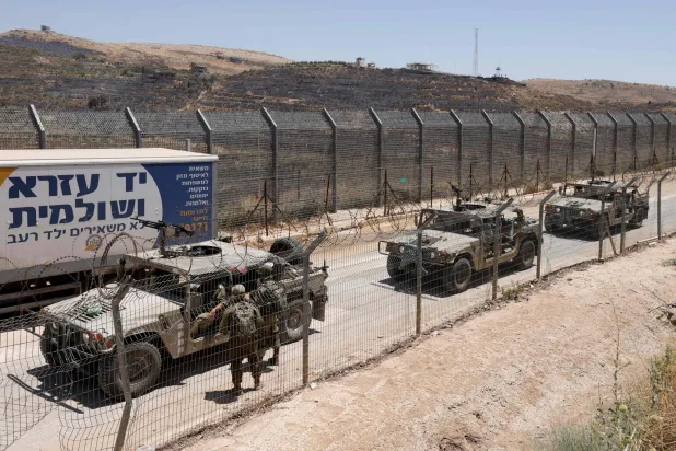 مركبات عسكرية إسرائيلية تسير على طول السياج الحدودي بالقرب من بلدة مجدل شمس، في مرتفعات الجولان التي ضمتها إسرائيل، 17 يوليو 2025 (أ.ف.ب)