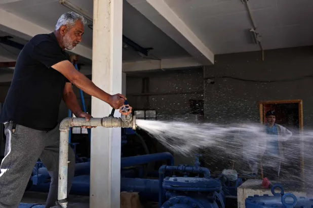 يراقب صبحي عليان مستوى الضغط في أنابيب المياه التي تنهل من عين سامية في الضفة الغربية (أ.ف.ب)