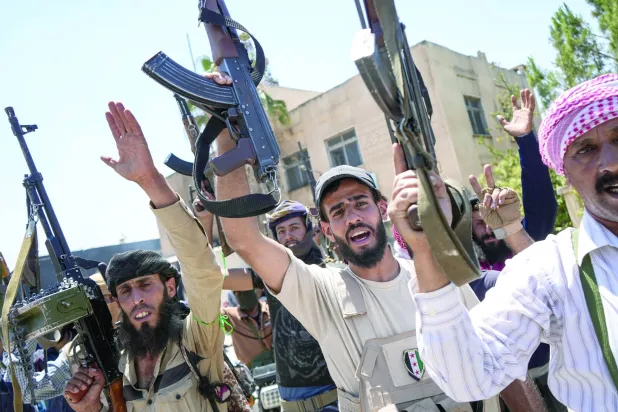 مقاتلون من العشائر البدوية في بلدة المزرعة ذات الأغلبية الدرزية في ريف السويداء (إ.ب.أ)