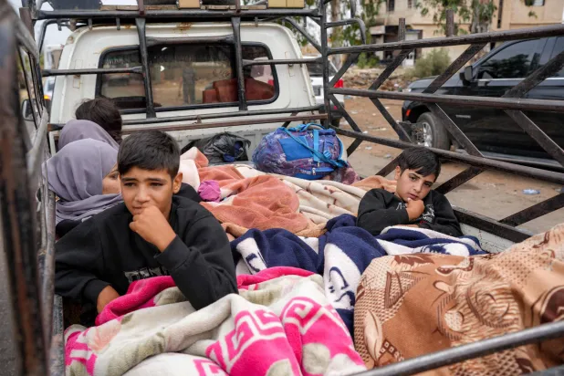 أفراد من البدو فوق شاحنة عند نقطة تفتيش أمنية في بلدة الطارة بمحافظة السويداء، جنوب سوريا، في طريقهم إلى درعا الاثنين (أ.ف.ب)