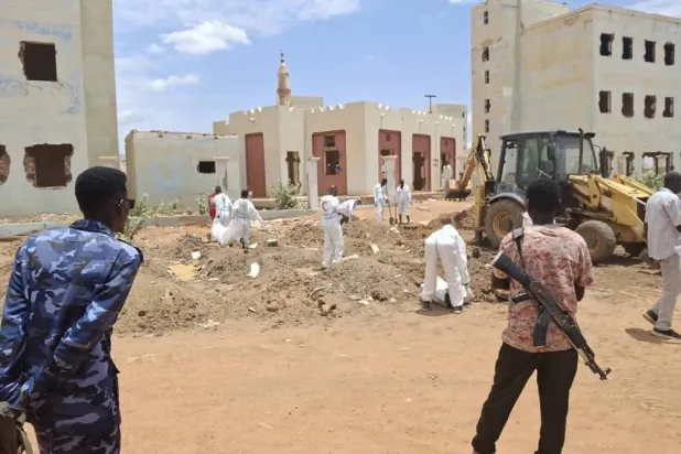 A Red Crescent team exhumes bodies from a mass grave in Khartoum. (Asharq Al-Awsat) 