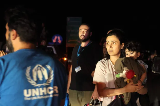 أُجليت عائلات من قِبل الأمم المتحدة عند المنطقة العازلة في بصر الحرير بمحافظة درعا جنوب سوريا الثلاثاء (أ.ف.ب)