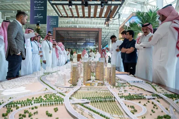 أشخاص ينظرون إلى نموذج مشروع «مسار مكة» في معرض «سيتي سكيب» المقام في الرياض (واس)