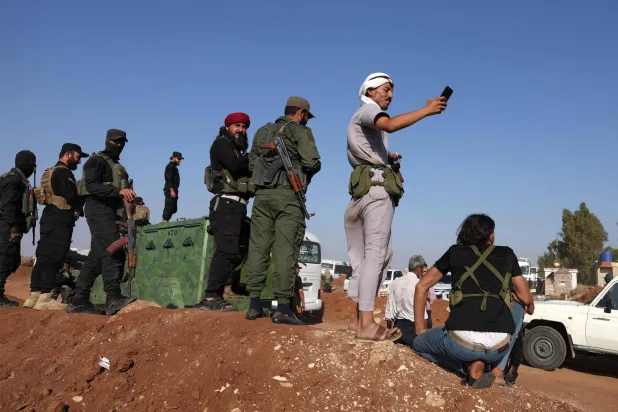 قوات الأمن السورية تتابع مرور قافلة الأمم المتحدة لإجلاء عائلات من السويداء عابرة المنطقة العازلة في بصر الحرير بمحافظة درعا جنوب سوريا الثلثاء (إ.ف.ب)