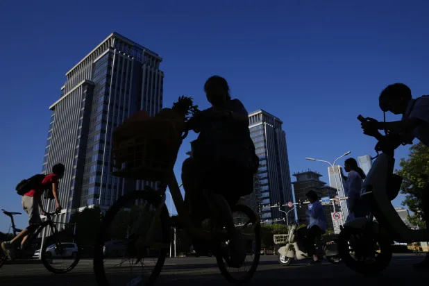 ركاب دراجات في إحدى المناطق السكنية بالعاصمة الصينية بكين (أ.ب)